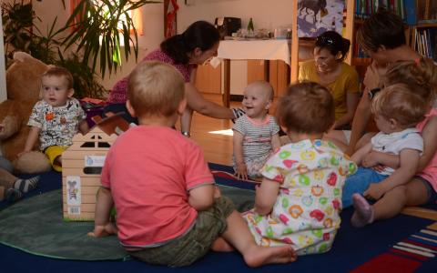Kinder sitzen am Boden und hören gespannt zu.